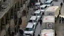 Warga sipil berkumpul di dekat konvoi truk bantuan Bulan Sabit Merah Suriah di Douma, Ghouta Timur, Damaskus, Suriah, Senin (5/3). Konvoi ini merupakan yang pertama sejak resolusi gencatan senjata pertengahan Februari lalu. (Syrian Red Crescent via AP)