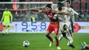 Pemain Cremonese Leonardo Sernicola (tengah) berebut bola dengan pemain AC Milan Fode Ballo-Toure (kanan) pada pertandingan sepak bola Serie A Liga Italia di Stadion Giovanni-Zini, Cremona, Italia, 8 November 2022. Pertandingan berakhir imbang 0-0. (Filippo MONTEFORTE/AFP)