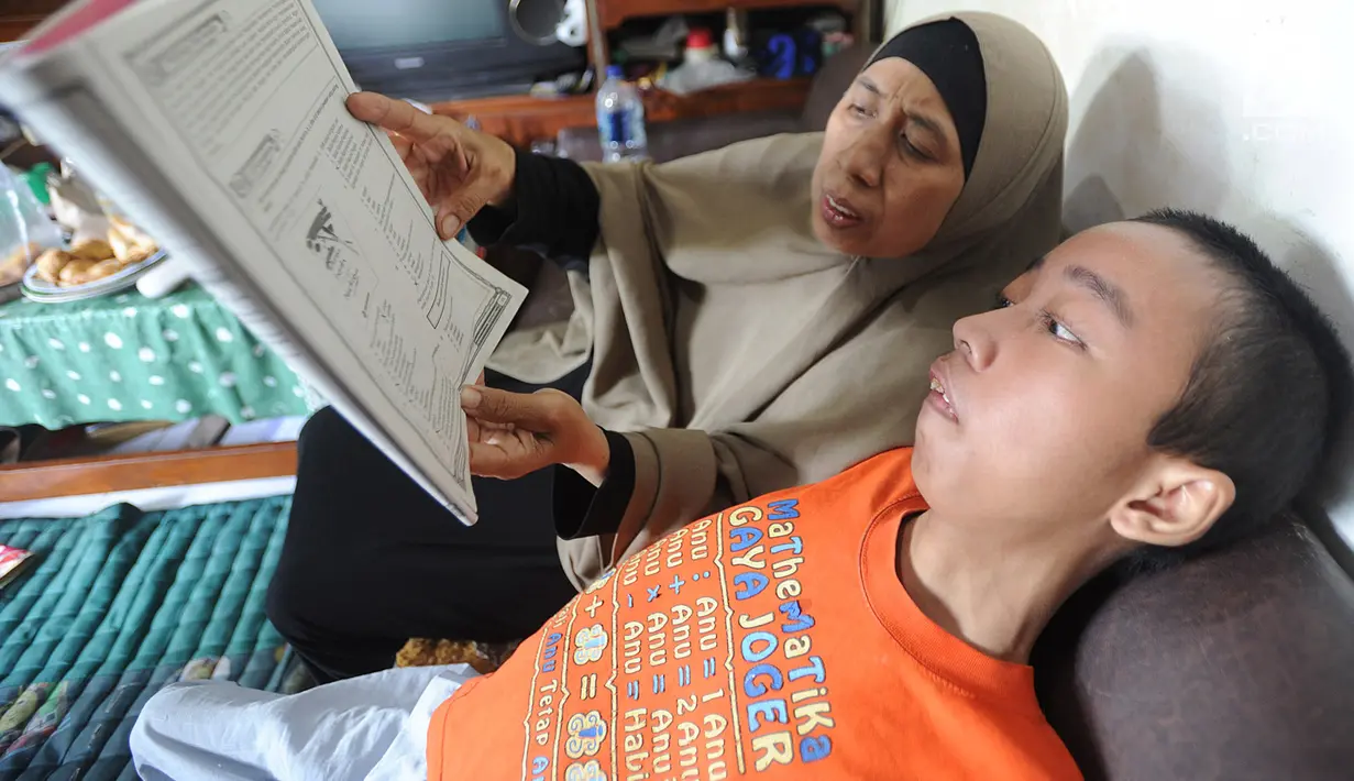 Fauzan Akmal Maulana belajar bersama ibunya, Winih Utami, di rumahnya, Kampung Pladen, Pondok Ranji, Ciputat, Tangerang Selatan, Jumat (22/3). Fauzan menderita DMP sejak tahun 2015, saat masih menginjak kelas 5 SD. (merdeka.com/Arie Basuki)