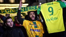 Mantan bintang FC Nantes, Emiliano Sala dikabarkan meninggal dunia usai pesawat yang ditumpanginya hilang dari kontak, selasa (22/1). Hal tersebut membuat pendukung FC Nantes larut dalam rasa duka. (AFP/Loic Venance)