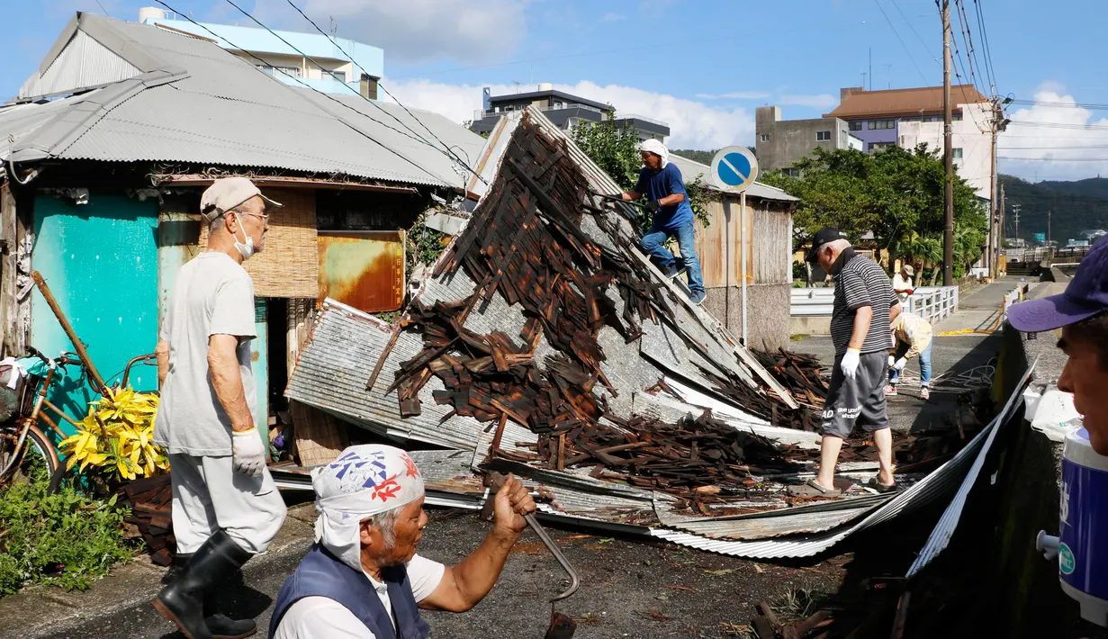 Warga memperbaiki atap yang rusak akibat angin kencang menyusul topan Haishen di Amami, prefektur Kagoshima, barat daya Jepang, Senin (7/9/2020). Topan kuat kedua yang melanda wilayah tersebut dalam sepekan ini menyebabkan sejumlah orang terluka dan banyak bangunan rusak. (Kyodo News via AP)