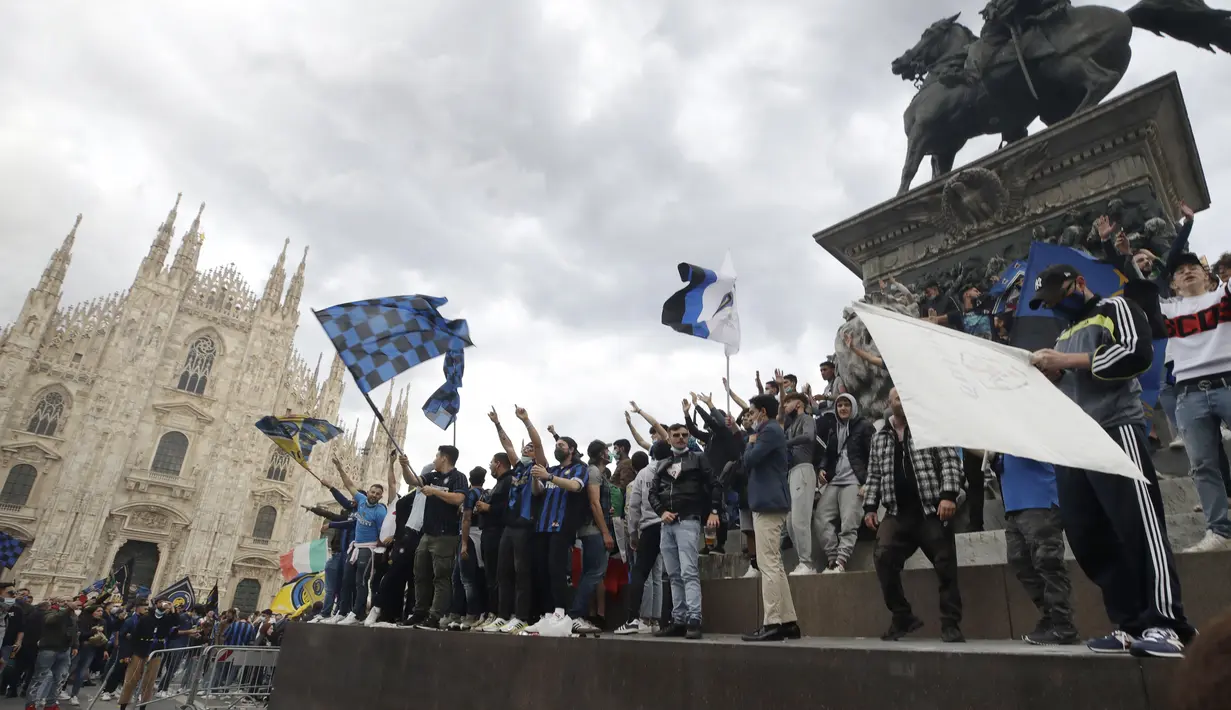 Suporter Inter Milan merayakan dan berteriak di alun-alun Piazza Duomo di depan katedral gotik setelah Inter Milan memenangkan gelar Serie A pertamanya dalam lebih dari satu dekade setelah tim urutan kedua Atalanta bermain imbang 1-1 di Sassuolo, di Milan, Italia (2/5/2021). (AP Photo/Luca Bruno)