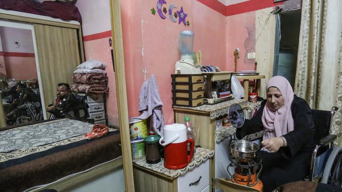 Zeinab Jarboa (35) menyiapkan makanan saat suaminya Nihad, 37, memandang, di rumah mereka di kamp pengungsi Rafah di Jalur Gaza selatan, pada 19 Juli 2020. (AFP Photo/Said Khatib)