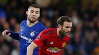 Gelandang Manchester United, Juan Mata berebut bola dengan pemain Chelsea, Mateo Kovacic pada laga putaran kelima Piala FA di Stamford Bridge, Senin (18/2). Manchester United lolos ke perempat final usai mengalahkan Chelsea 2-0. (AP/Alastair Grant)
