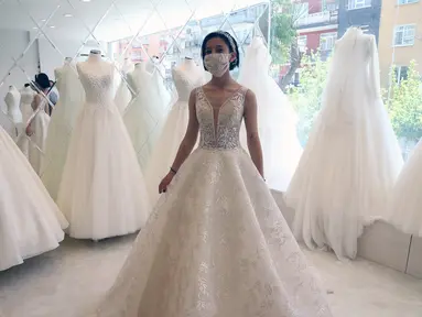 Seorang pelanggan mencoba gaun pengantin yang dirancang khusus dengan masker di Ankara, Turki, Sabtu (6/6/2020). Hingga 6 Juni 2020, total kasus COVID-19 di Turki melonjak menjadi 169.218. (Xinhua/Mustafa Kaya)