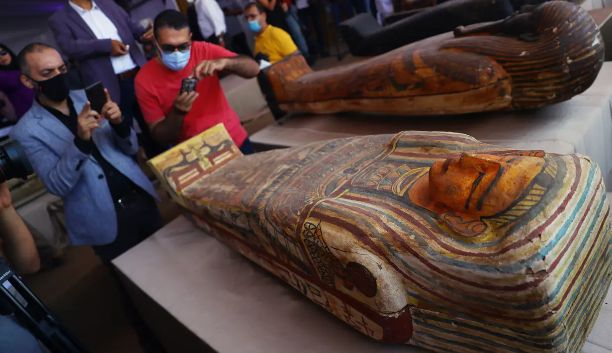 Sejumlah orang mengabadikan foto peti mati kuno yang baru ditemukan di situs pemakaman Saqqara di Provinsi Giza, Mesir, 3 Oktober 2020. Kementerian Pariwisata dan Kepurbakalaan Mesir memamerkan 59 peti mati kuno yang baru ditemukan dengan kondisi terawat baik di Provinsi Giza. (Xinhua/Ahmed Gomaa)