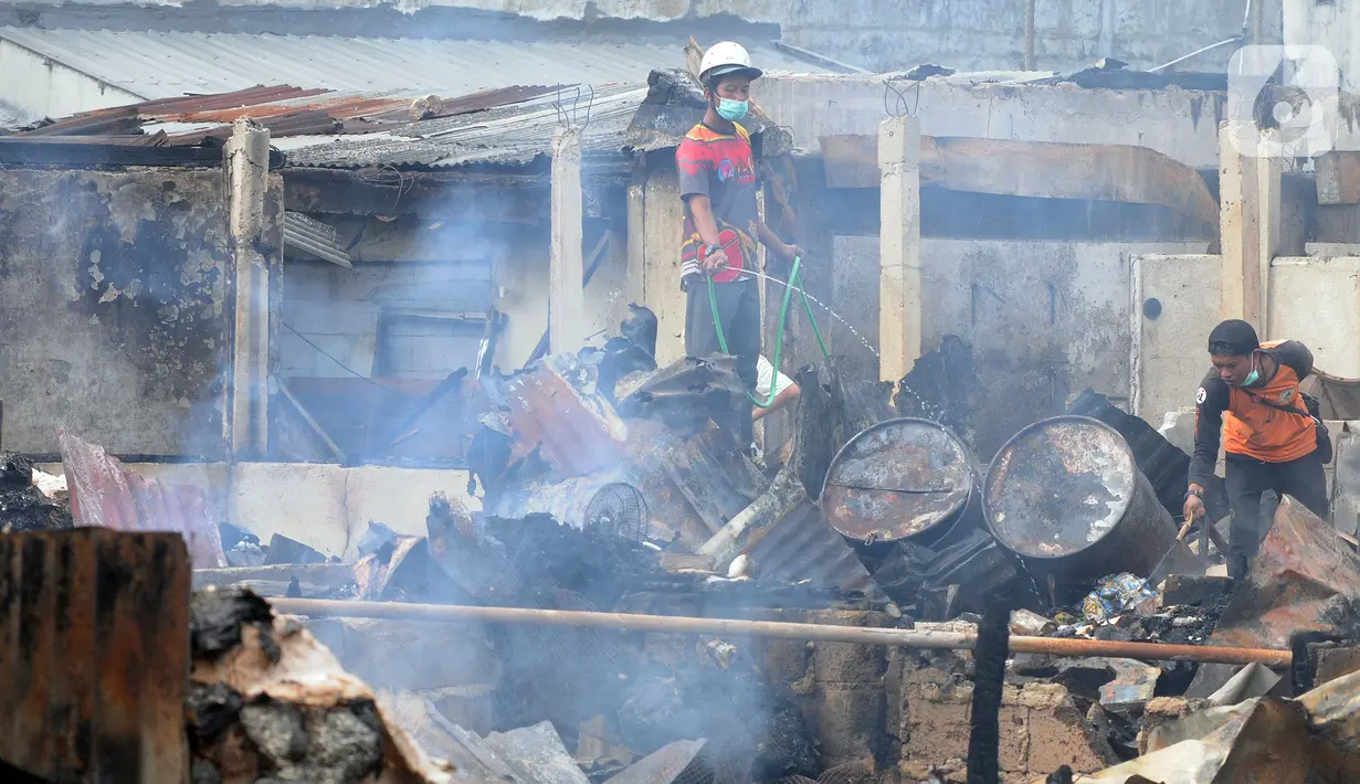 Pedagang menyiram air pada sisa bara api lokasi kebakaran Pasar Ciputat, Tangerang Selatan, Banten, Kamis (12/5/20222). Kebakaran Pasar Ciputat pada kemarin sore menghanguslan lebih dari 50 kios dan rumah warga yang berada di sekitar pasar. (merdeka.com/Arie Basuki)
