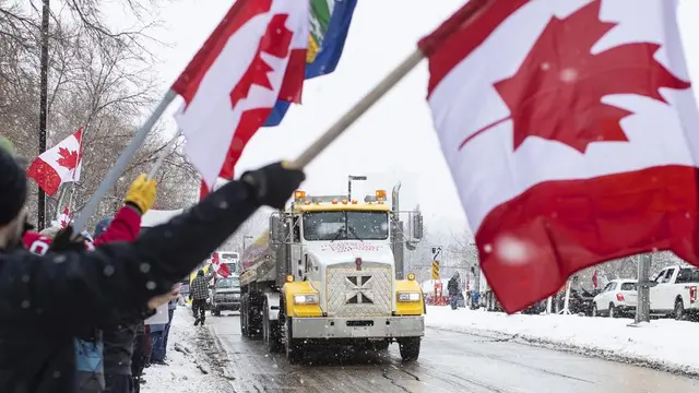 Orang-orang berkumpul untuk memprotes mandat COVID-19 dan mendukung protes terhadap pembatasan COVID-19 yang berlangsung di Ottawa, di Edmonton, Alberta, Sabtu, 5 Februari 2022. (Jason Franson/The Canadian Press via AP)