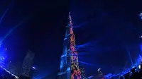 Menara tertinggi di dunia, Burj Khalifa, memancarkan sinar laser pada malam perayaan Tahun Baru di Dubai, 1 Januari 2018. Burj Khalifa bermandikan sinar laser hijau, putih, hitam dan merah yang mewakili  warna bendera negara itu. (Giuseppe CACACE/AFP)
