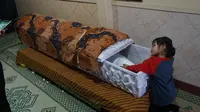 Salah satu anak almarhum sedang melihat jenazah ayahnya.(Liputan6.com/Fajar Abrori)