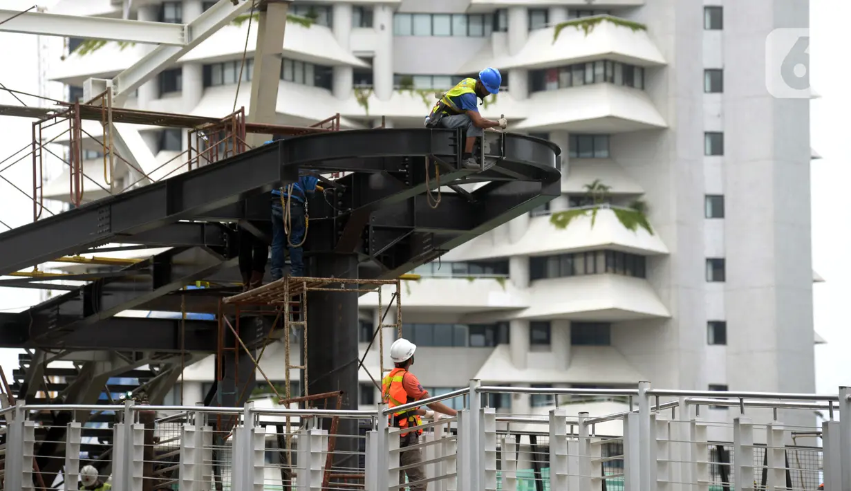 Pekerja menyelesaikan proyek Tugu Tenaga Kesehatan di Jembatan Penyeberangan Orang (JPO) Sudirman, Jakarta, Jumat (12/11/2021). Pemprov DKI Jakarta membuat Tugu Tenaga Kesehatan untuk menghormati tenaga kesehatan yang gugur selama pandemi COVID-19. (merdeka.com/Imam Buhori)