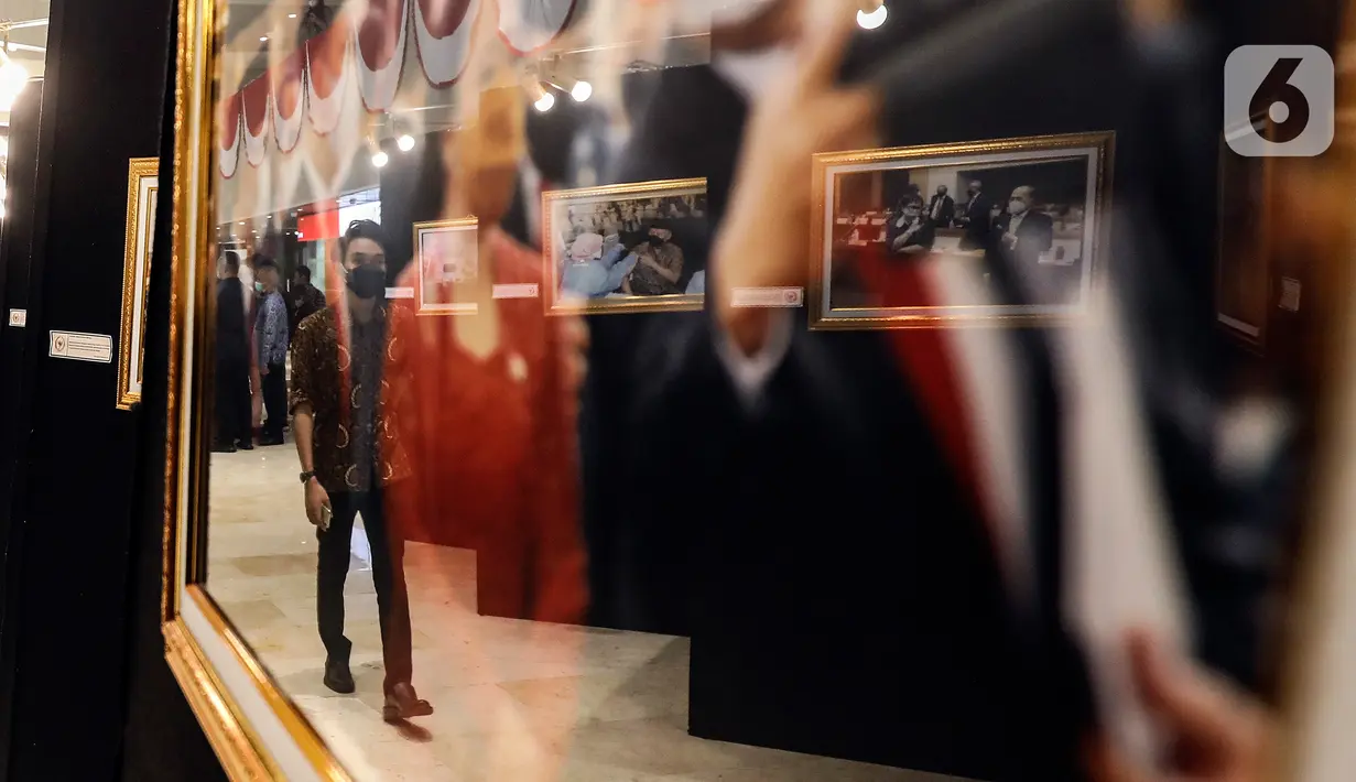 Refleksi gambar pengunjung terlihat pada bingkai foto dalam Pameran Foto Jurnalistik Warna-Warni Parlemen dengan tema Bangkit Lebih Cepat di loby Nusantara II DPR, Senayan, Jakarta, Senin (29/8/2022). DPR RI melalui KWP melaksanakan pameran foto jurnalistik yang merekam kegiatan-kegiatan pimpinan dan anggota DPR RI selama bertugas. (Liputan6.com/Johan Tallo)