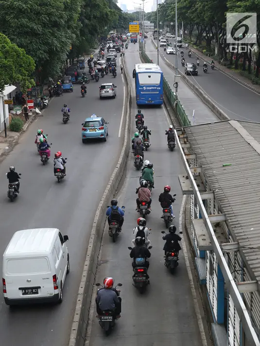 Pengendara motor melaju di belakang bus Transjakarta di kawasan Pasar Rumput, Jakarta, Rabu (20/2). Kamera pengawas atau CCTV akan dipasang di setiap halte Transjakarta yang terintegrasi dengan Ditlantas Polda Metro Jaya. (Liputan6.com/Immanuel Antonius)