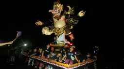 Sejumlah pemuda mengarak Ogoh-Ogoh atau boneka raksasa menjelang Hari Raya Nyepi Tahun Saka 1940 di Bali, Kamis (15/3). Parade Ogoh-Ogoh itu bertujuan agar Hari Raya Nyepi dapat dilaksanakan dengan penuh keheningan dan kedamaian. (AP/Firdia Lisnawati)