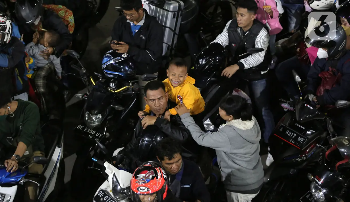<p>Pemudik bersepeda motor dengan membawa anak antre menunggu giliran masuk ke kapal "Roll on-Roll off" (RoRo) di Pelabuhan Merak, Banten, Kamis (28/4/2022). Puncak arus mudik H-3 lebaran di Pelabuhan Merak sudah dipenuhi oleh pemudik. Tampak, pemudik yang membawa anak kecil serta barang bawaan yang diikat di belakang motor. (Liputan6.com/Angga Yuniar)</p>