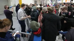 Pekerja (kiri) meminta pengunjung pergi saat toko IKEA tutup di pinggiran St. Petersburg, Kamis (3/3/2022). Peritel IKEA menghentikan operasional di "Negeri Beruang Merah" dan Belarusia untuk sementara waktu mulai Jumat, 4 Maret 2022 buntut dari invasi Rusia ke Ukraina. (AP Photo/Dmitri Lovetsky)