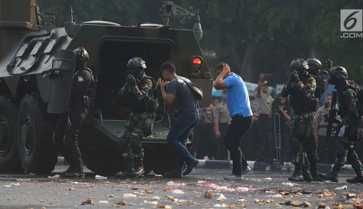 Personel tentara dan polisi mengamankan perusuh dalam apel pengamanan Asian Games 2018 di Lapangan Ditlantas Polda Metro Jaya, Jakarta, Selasa (31/7). (Merdeka.com/Imam Buhori)