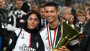 Striker Juventus, Cristiano Ronaldo bersama kekasihnya Georgina Rodriguez berpose bersama Piala Liga Italia Serie A usai menjuarainya untuk ke-33 kalinya di Stadion Allianz, Turin (19/5/2019). (AP Photo/Antonio Calanni)