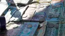 Sejumlah uang kertas Irak yang bergambar mantan Presiden Irak, Saddam Hussein yang dijual disebuah pasar di Baghdad, Irak (28/12). Pada tahun 2003 mata uang yang bergambar Saddam Hussein ini  diganti dengan mata uang Dinar Irak yang baru. (AFP/Sabah Arar)