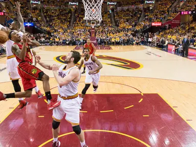 LeBron James (kiri) menghadang tembakanpemain Atlanta Hawks, Jeff Teague #0 pada partai kedua semifinal Wilayah Timur NBA, di Quicken Loans Arena, Kamis (5/5/2016) WIB.  Jason Miller/Getty Images/AFP