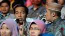 Jokowi dihampiri oleh Irfan Hakim saat berada di bangku penonton acara Putri Muslimah Indonesia 2014 (Liputan 6.com/Andrian M Tunay)