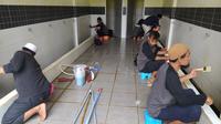 Sesuai dengan tugasnya, beberapa anggota komunitas nampak tengah membersihkan tempat wudlu dan kamar mandi masjid Agung Sirotul Jannah, Cikelet, Garut  (Liputan6.com/Jayadi Supriadin)