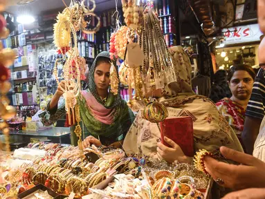 Sejumlah perempuan Pakistan memilih pernak-pernik di sebuah pasar di Lahore, Selasa (12/6). Umat muslim di berbagai penjuru dunia sedang mempersiapkan untuk merayakan Idul Fitri, yang menandai berakhirnya bulan suci Ramadan. (AFP/ARIF ALI)