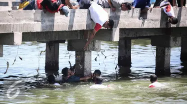 Warga berusaha menolong seorang anak kecil yang terjatuh ke laut di dermaga Muara Angke, Jakarta, Kamis (24/3). Akibat kelalaian ibunya seorang anak tercebur ke laut dan langsung di selamatkan warga dan prajurit TNI AL. (Liputan6.com/Faizal Fanani)