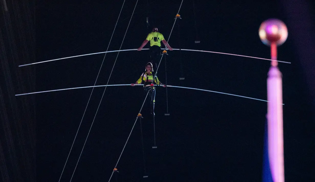 Aerialists Nik Wallenda (kanan) dan saudara perempuannya Lijana Wallenda melintasi seutas kawat di ketinggian 396 meter, Times Square, New York, AS, Minggu (23/6/2019). Keduanya melintasi kawat yang terbentang di antara dua gedung pencakar langit setinggi 25 lantai. (Johannes EISELE/AFP)