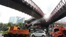 Petugas menyemprotkan air bertekanan tinggi ke permukaan jalan dalam operasi water mist untuk mengendalikan partikel debu akibat sebaran abu vulkanik Gunung Anak Krakatau di Jakarta. (KLY/Budy Santoso)