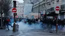 Anggota komunitas Kurdi berdiri di tengah asap gas air mata saat mereka bentrok dengan petugas polisi dekat TKP tempat terjadinya penembakan di Paris, Prancis, 23 Desember 2022. Demo tersebut diwarnai bentrokan antara pengunjuk rasa dan aparat keamanan yang berakhir dengan lemparan batu hingga pembakaran tempat sampah. (AP Photo/Lewis Joly)