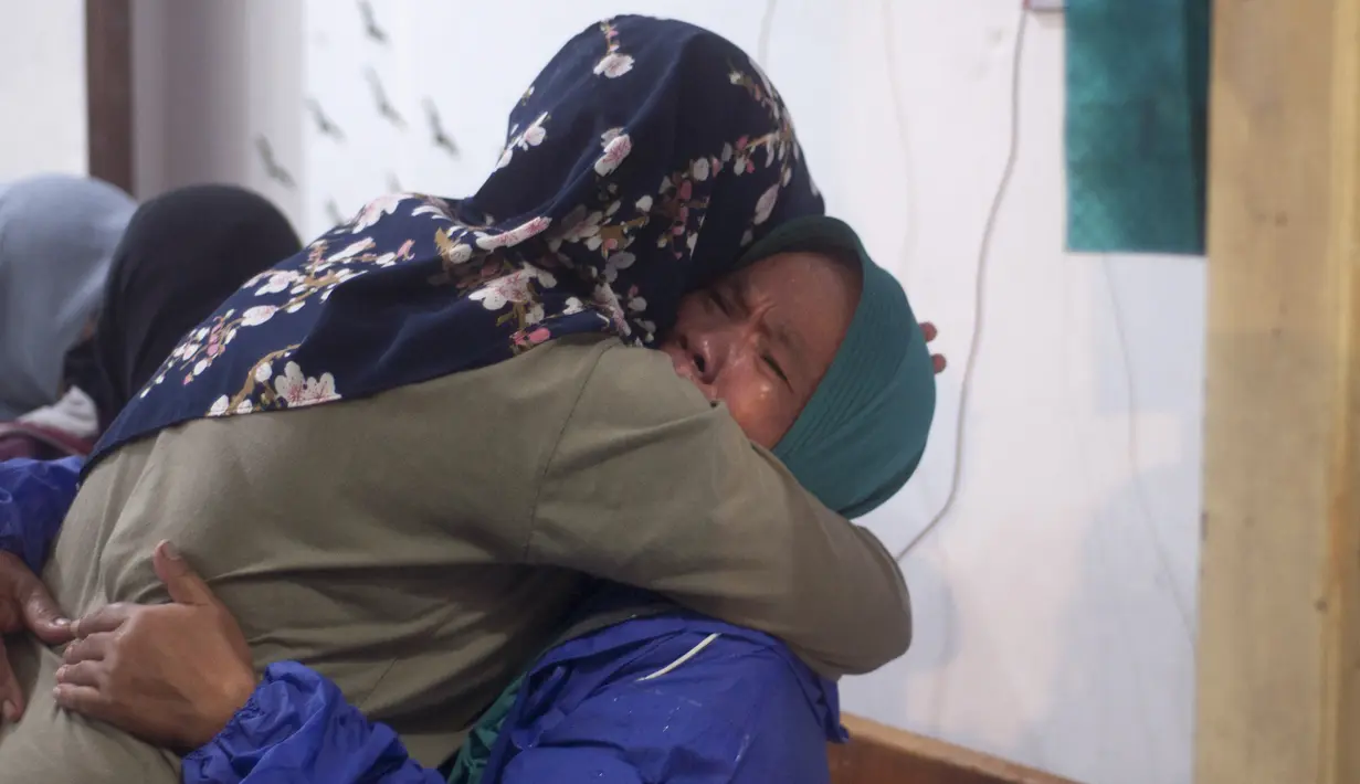 Kerabat berpelukan saat menanti kabar kondisi siswa SMPN 1 Turi korban banjir bandang di Sungai Sempor, Sleman, Yogyakarta, Jumat (21/2/2020). Hingga Sabtu (22/2)jumlah korban jiwa berjumlah tujuh orang dan hilang dilaporkan tiga orang serta luka-luka 23 orang. (AP Photo/Slamet Riyadi)