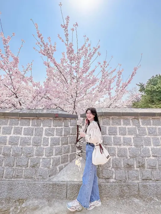 Pilihan kemeja dengan aksen ruffle dan lengan gelembung juga jadi ciri ala fashion Korea yang manis dan romantis. [IG @amelia_tantono]