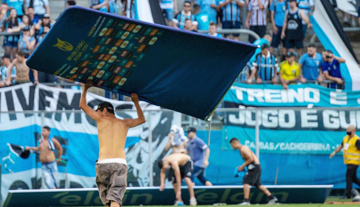 Kekalahan 1-3 Gremio atas Palmeiras langsung memantik emosi suporter Gremio untuk melakukan perilaku bar-bar. Para fans yang murka tersebut nekat memasuki lapangan dan merusak monitor Virtual Assistant Referee (VAR). (AFP/Raul Pereira)