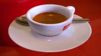 Secangkir kopi pekat yang disebut espresso, disajikan dicangkir keramik.