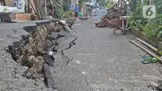 Warga melintasi sisi ruas jalan yang ambles di Jalan Kesatria, Matraman, Jakarta, Selasa (3/3/2020). Hujan lebat yang mengguyur Ibu Kota beberapa waktu lalu mengakibatkan ruas jalan sepanjang 100 meter di kawasan tersebut retak dan ambles. (Liputan6.com/Herman Zakharia)