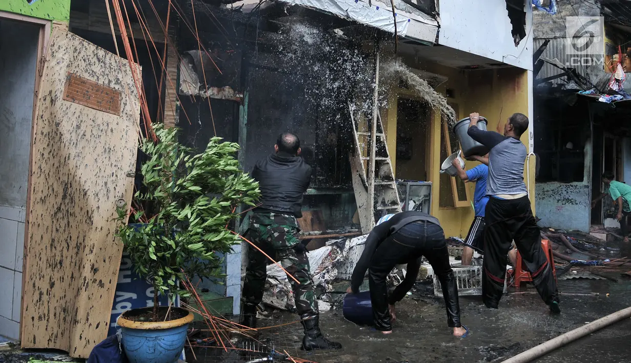 Warga membantu petugas pemadam kebakaran menjinakkan kobaran api yang membakar permukiman di kawasan Tanah Tinggi, Johar Baru, Jakarta, Selasa (26/6). Kebakaran menghanguskan puluhan rumah. (Merdeka.com/Iqbal Nugroho)