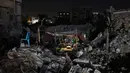 Warga Palestina duduk di tenda yang didirikan di atas reruntuhan bangunan yang hancur dalam serangan udara Israel di Kota Gaza (24/5/2021). Sementara itu, roket dari Gaza merenggut 12 nyawa di Israel, termasuk satu anak dan seorang tentara Israel. (AFP/Mohamed Abed)
