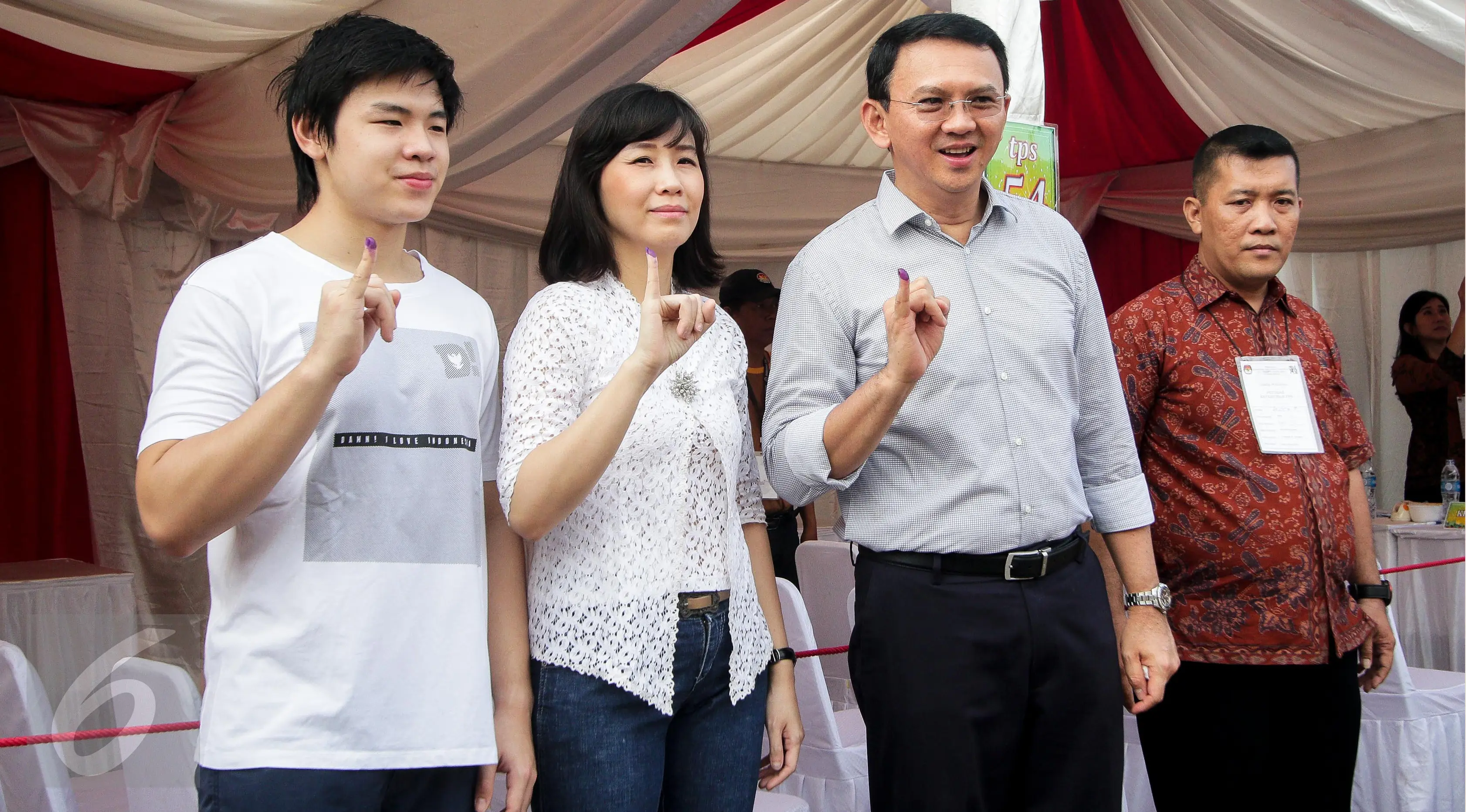 Calon gubernur DKI, Basuki Tjahaja Purnama (Ahok) bersama istri, Veronica Tan dan anaknya Nicholas Sean menunjukkan tinta pada jarinya usai mencoblos pada Pilkada DKI putaran kedua di TPS 54, Pluit, Jakarta Utara, Rabu (19/4). (Liputan6.com/Faizal Fanani)