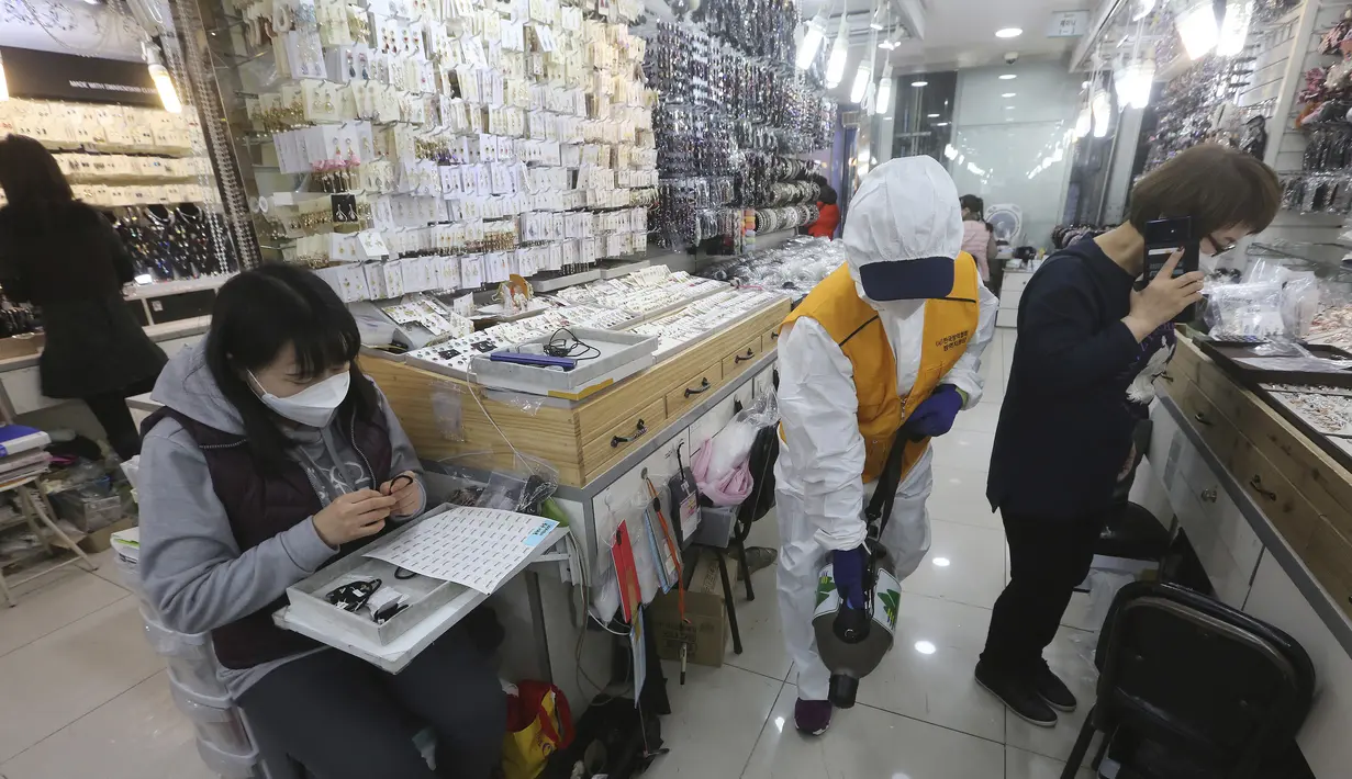 Pekerja mengenakan pakaian pelindung menyemprotkan disinfektan sebagai tindakan pencegahan terhadap virus corona baru di Pasar Namdaemun di Seoul, Korea Selatan, Rabu, (5/2/2020). Kematian akibat virus corona naik menjadi 490 di daratan China pada Rabu (5/2). (AP Photo/Ahn Young-joon)