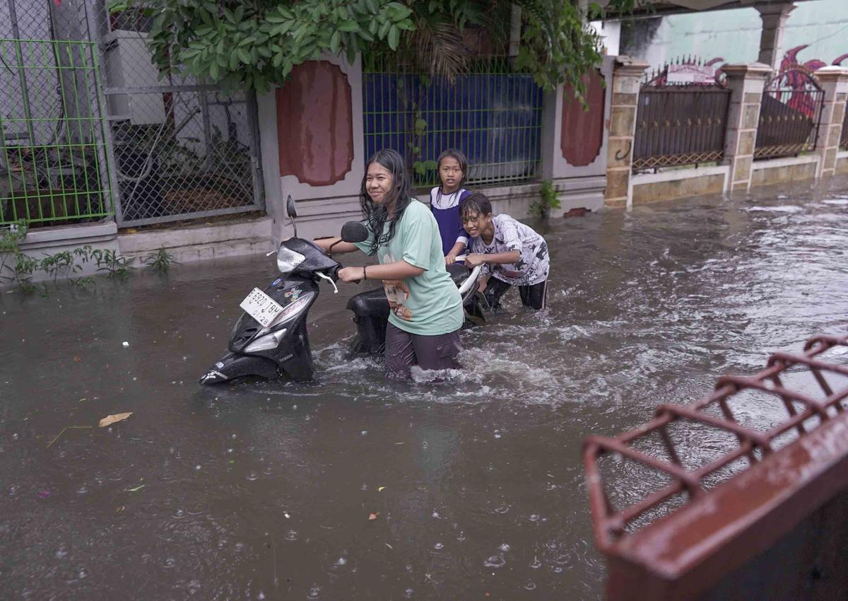 FOTO: Drainase Meluap, Warga Pasar Rebo Terobos Genangan