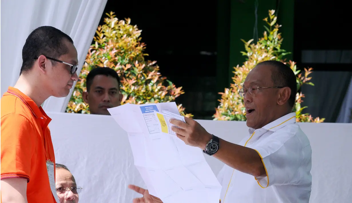 Aburizal Bakrie memeriksa kertas suara sebelum menggunakan hak pilihnya di TPS 32 Menteng, Jakarta Pusat, Rabu (9/4) (Liputan6.com/Andrian M Tunay)