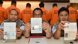 Petugas menunjukan pasport WNA saat rilis di kantor Imigrasi Kelas 1 Jakarta Timur, Rabu (18/1). Sebanyak 11 wna diamankan petugas imigrasi karena tidak memiliki surat resmi. (Liputan6.com/Yoppy Renato)