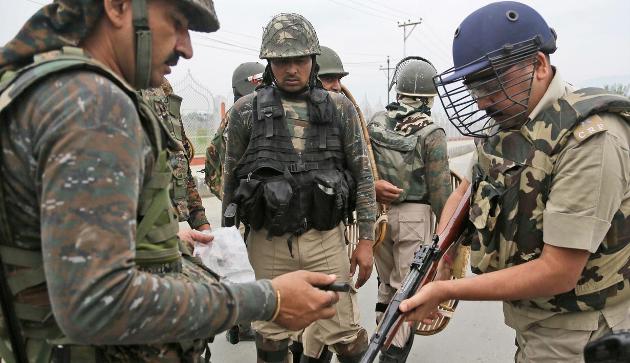 Seorang perwira tentara mengisi senjatanya saat ingin membubarkan aksi demontrasi usai salat Idul Fitri di Srinagar, India (26/6). Pasukan keamanan setempat berusaha membubarkan para demonstran dengan menembakan gas air mata. (AP Photo / Mukhtar Khan)