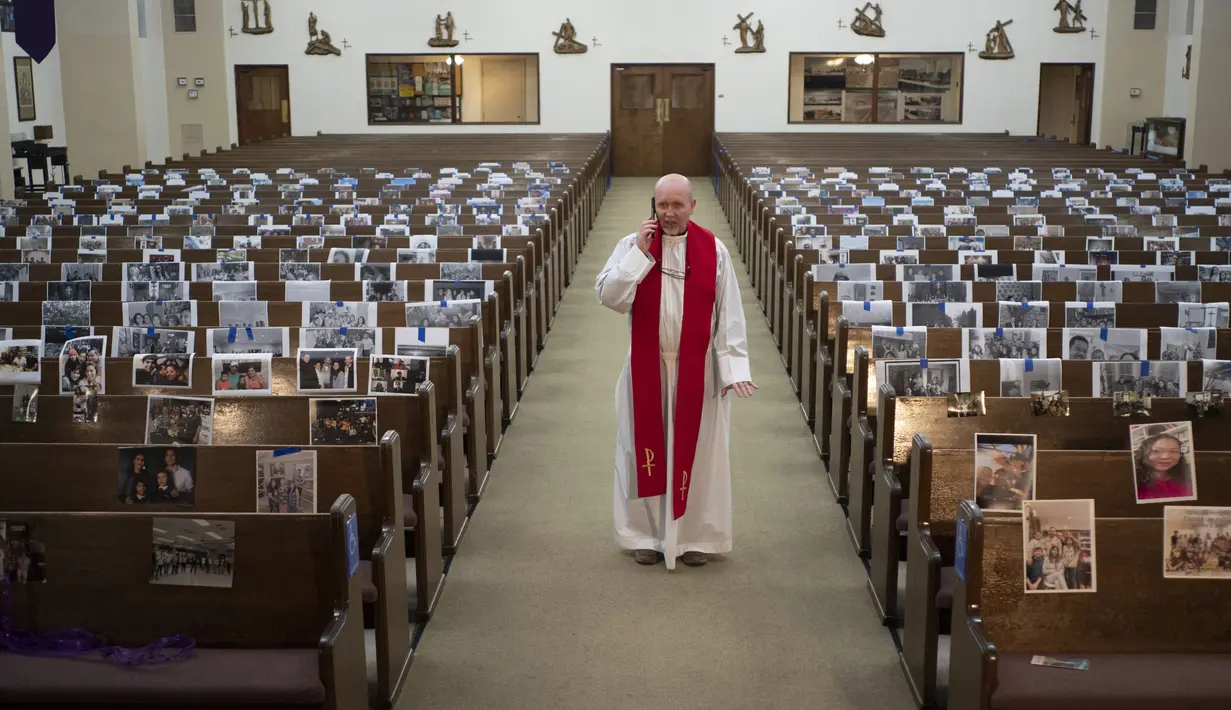 Pendeta Nicolas Sanchez menerima telepon dari seorang anggota paroki setelah siaran langsung misa Jumat Agung selama pandemi virus corona COVID-19 di Gereja Katolik St. Patrick, Los Angeles, Amerika Serikat, Jumat (10/4/2020). (AP Photo/Damian Dovarganes)