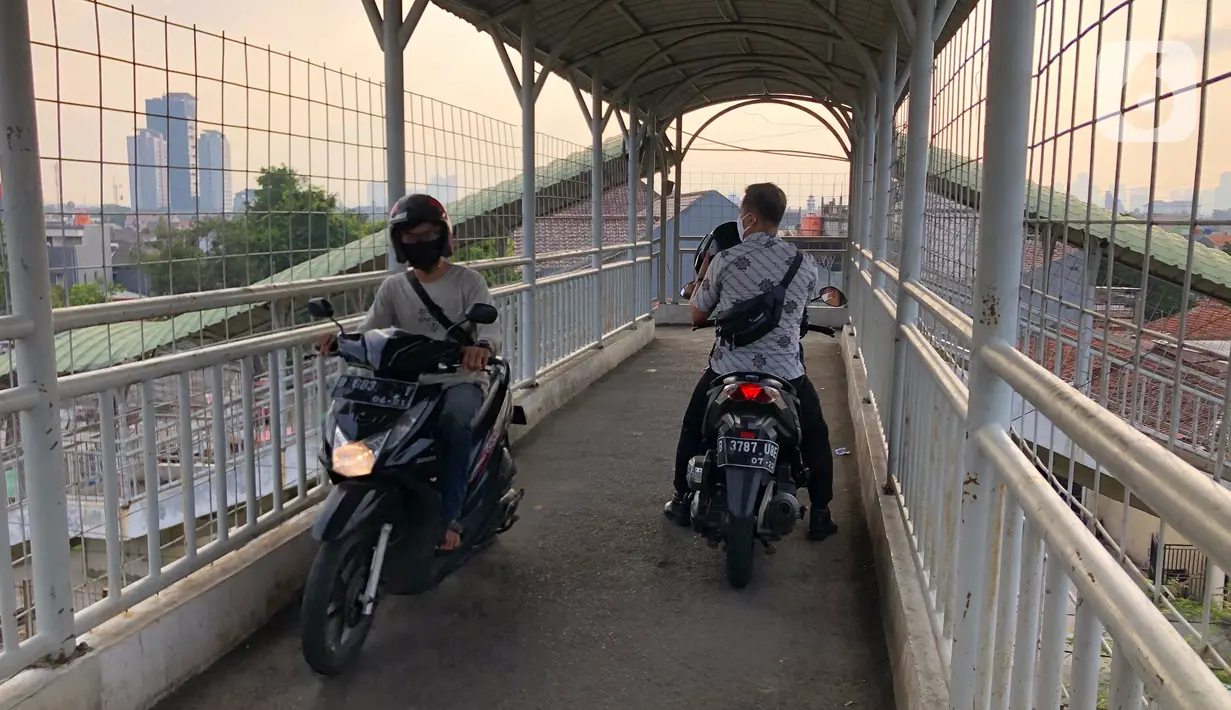 Pengendara sepeda motor melintasi Jembatan Penyeberangan Orang (JPO) di kawasan Pasar Minggu, Jakarta, Jumat (17/7/2020). Rendahnya kesadaran dalam disiplin berkendara menyebabkan sejumlah pengendara sepeda motor melintasi JPO tersebut meski merugikan pengguna lain. (Liputan6.com/Immanuel Antonius)