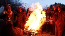 Para peserta mengenakan kostum iblis membuat api unggun saat parade tardisional Perchtenlauf di Osterseeon dekat Munchen, Jerman (17/12). Tradisi ritual Pagan ini telah berusia 1.500 tahun (Reuters/Michaela Rehle)