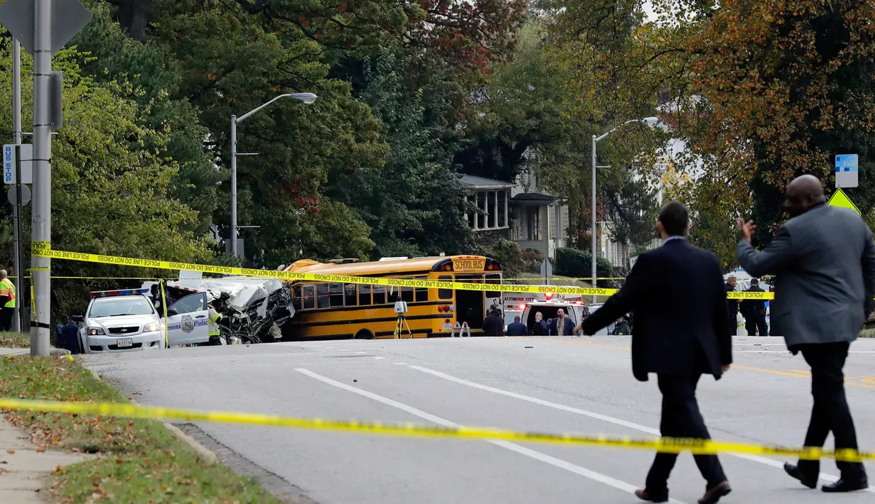 Pejabat setempat meninjau lokasi kecelakaan antara bus komuter dengan bus sekolah di Baltimore, Maryland, Selasa (1/11). Hingga saat ini, otoritas berwenang di Baltimore belum memberikan informasi terkait penyebab kecelakaan. (AP Photo/Patrick Semansky)