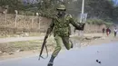 Seorang polisi melompat ketika dia berusaha menghindari granat gas air mata yang dilemparkan kembali ke arah polisi oleh pengunjuk rasa di lingkungan Mathare di Nairobi, Kenya Rabu, 12 Juli 2023. (AP Photo)