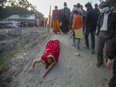 Seorang umat Hindu Nepal berbaring sujud, sebagai bagian dari ritual, di tepi Sungai Bagmati selama festival Chhath Puja di Kathmandu, Nepal, Rabu (10/11/2021). Selama Chhath, sebuah festival Hindu kuno, ritual dilakukan untuk terima kasih kepada Dewa Matahari. (AP Photo/Niranjan Shrestha)